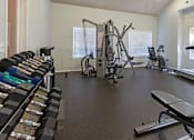 Thumbnail 16 of 25 - a gym with cardio equipment and weights on the floor