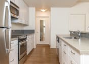 Thumbnail 19 of 33 - a kitchen with stainless steel appliances and white cabinets