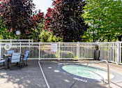 Thumbnail 17 of 25 - a hot tub with a table and chairs next to a fence