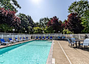 Thumbnail 18 of 25 - a swimming pool with chairs and a table next to it