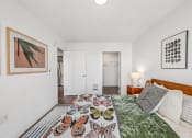 Thumbnail 7 of 53 - a bedroom with white walls and a bed with a colorful comforter