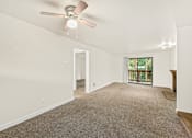 Thumbnail 10 of 26 - A room with a ceiling fan and carpeted floor.