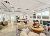 Thumbnail 25 of 32 - A modern office space with a variety of seating options and a long table.