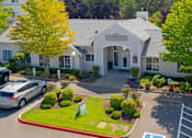 Thumbnail 23 of 25 - a large white building with cars parked in front of it