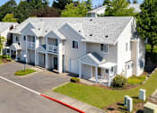 Thumbnail 38 of 38 - A white building with a parking lot in front.