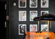 Thumbnail 22 of 53 - a desk with a lamp and pictures on the wall
