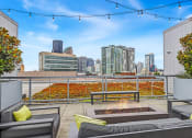 Thumbnail 13 of 27 - the rooftop patio with couches and a fire pit and a view of the city
