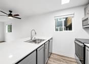 Thumbnail 9 of 13 - A kitchen with a white countertop and a window.