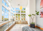Thumbnail 2 of 42 - a lobby with large windows and a table with a potted plant