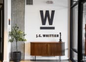 Thumbnail 17 of 53 - a living room with a wooden cabinet and a large letter on the wall