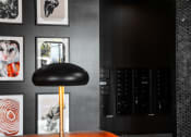 Thumbnail 29 of 53 - a black wall with pictures and a black chair with a gold lamp