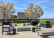 Thumbnail 27 of 38 - a patio with chairs and tables and trees on a roof