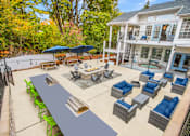 Thumbnail 17 of 26 - A patio with a table and chairs is surrounded by trees.