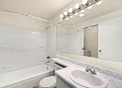 Thumbnail 15 of 26 - A white bathroom with a toilet, sink, and bathtub.