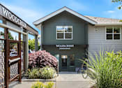 Thumbnail 7 of 34 - The front of the Woodcreek Apartments building with a sign and a door.