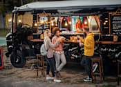 Thumbnail 6 of 8 - Three people are standing in front of a food truck.