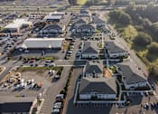 Thumbnail 34 of 34 - A large building complex with a parking lot in front.