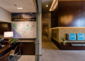 Thumbnail 19 of 48 - a lobby with a map of the city on the wall and a couch with blue pillows