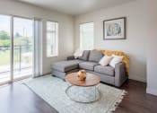 Thumbnail 3 of 48 - a living room with a gray couch and a glass coffee table