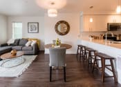 Thumbnail 4 of 48 - a living room and kitchen area with white walls and wood flooring
