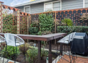Thumbnail 27 of 33 - a backyard with a wooden table and chairs and a privacy fence