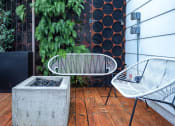Thumbnail 2 of 33 - a patio with two chairs and a concrete fire pit