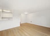 Thumbnail 30 of 49 - Empty room with wooden flooring and white walls.