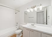 Thumbnail 22 of 49 - A white bathroom with a toilet, sink, and mirror.