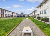 Thumbnail 4 of 15 - a path leading to a building in the middle of a grassy area