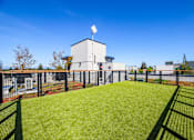 Thumbnail 33 of 49 - A white building with a solar panel on top is surrounded by a green fence.