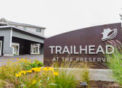 Thumbnail 18 of 24 - a sign for trailhead at the preserve with flowers in front of it