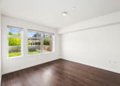 Thumbnail 39 of 48 - a living room with wood floors and white walls and windows