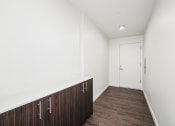 Thumbnail 46 of 48 - a corridor with white walls and wood floors and a white door