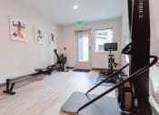 Thumbnail 14 of 24 - a home gym with exercise equipment and paintings on the wall