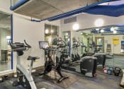 Thumbnail 15 of 26 - a gym with various cardio machines and a large glass window
