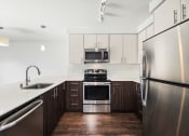 Thumbnail 28 of 48 - a modern kitchen with stainless steel appliances and white counter tops