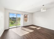Thumbnail 37 of 48 - an empty living room with wood floors and a sliding glass door