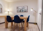 Thumbnail 12 of 24 - a dining room with a wooden table and blue chairs