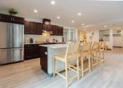 Thumbnail 8 of 24 - a kitchen with stainless steel appliances and a large island with chairs