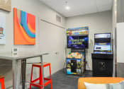 Thumbnail 19 of 26 - a room with two games and a table with orange chairs