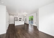 Thumbnail 31 of 48 - a living room and kitchen with white walls and wood floors