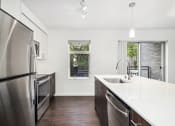 Thumbnail 34 of 48 - a kitchen with stainless steel appliances and a large counter top