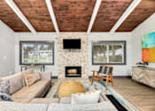 Thumbnail 11 of 49 - A living room with a fireplace and a television on the wall.