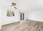 Thumbnail 7 of 25 - an empty living room with white walls and a ceiling fan