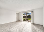 Thumbnail 39 of 49 - an empty living room with sliding glass doors to a patio