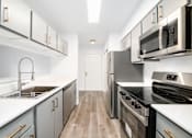 Thumbnail 4 of 25 - a modern kitchen with white counter tops and stainless steel appliances