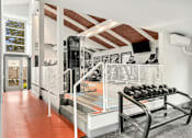 Thumbnail 14 of 49 - a gym with a rack of dumbbells and a screen on the wall