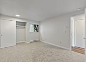 Thumbnail 21 of 29 - A large empty room with a window and a door.