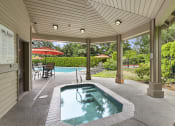 Thumbnail 28 of 29 - a covered patio with a jacuzzi and a pool