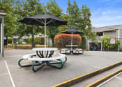 Thumbnail 15 of 22 - two tables with umbrellas in an empty parking lot